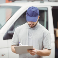 delivery man writing on clipboard in front of his PEYV53A